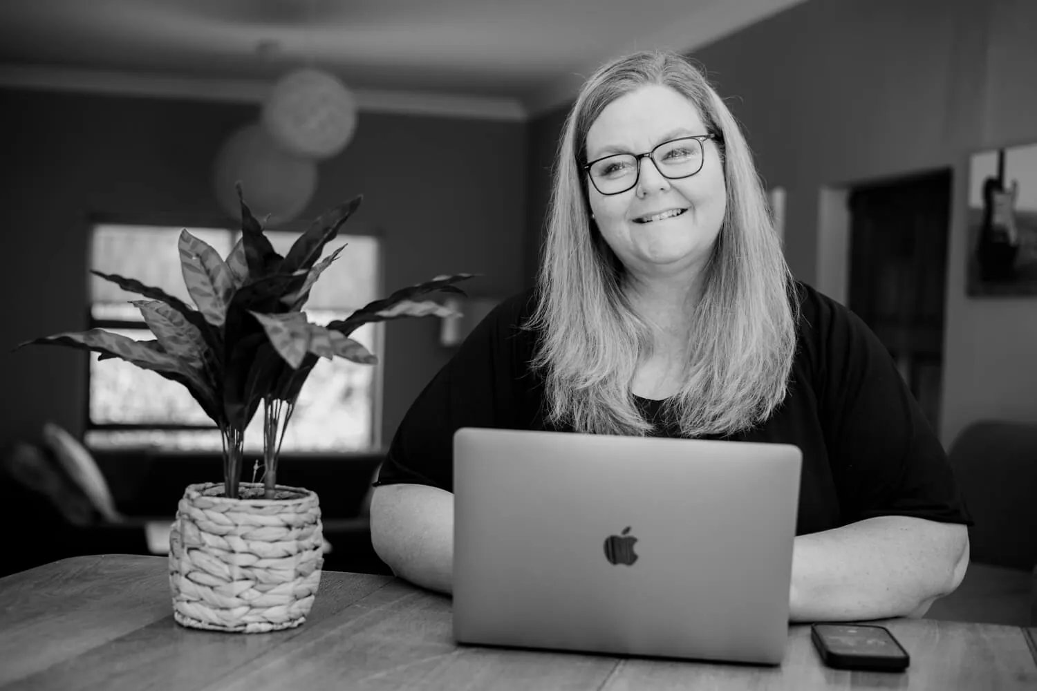 Petro Stroud smiling at her laptop in her home studio