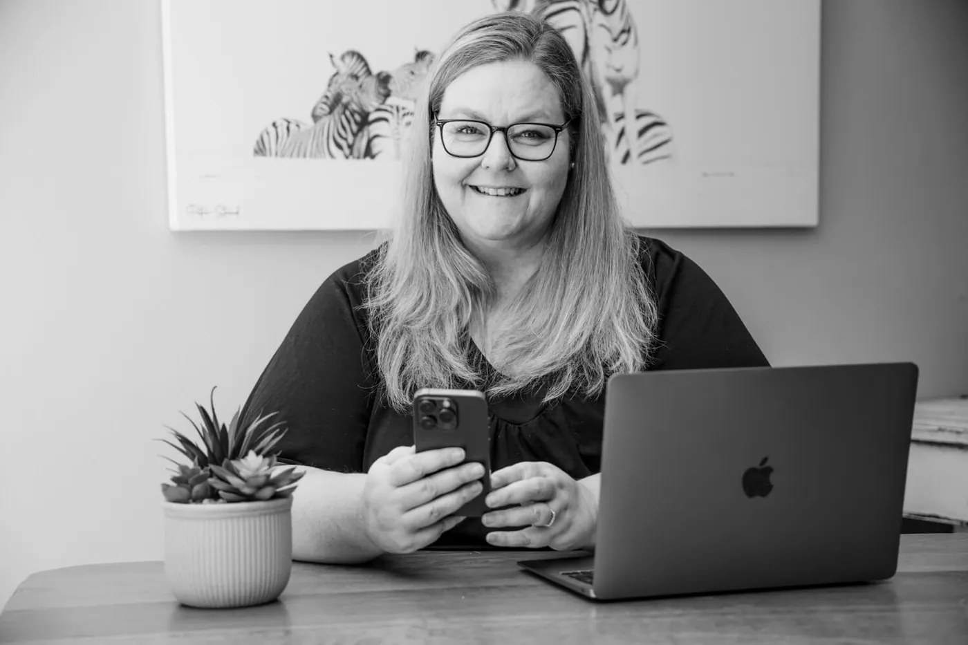 Petro at her desk in front of a zebra artwork